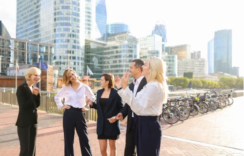 A group of professionals talking and laughing outside.